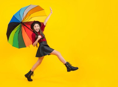 Child wuth umbrella under rain. Rainy weather, seasonal autumn. Excited teenager, glad amazed and overjoyed emotions