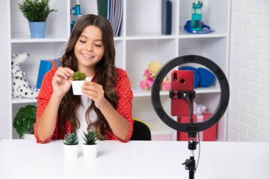 Gençler çevrimiçi medya videosu kaydediyor. Genç kız çevrimiçi yayın yapıyor ve cep telefonu uygulaması ile sosyal medya içeriğini paylaşıyor. Mutlu kız yüzü, pozitif ve gülümseyen duygular