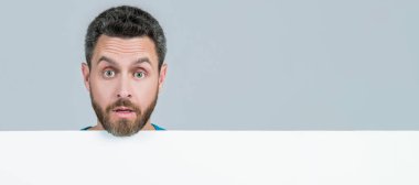 Man face portrait, banner with copy space. amazed male behind black paper. surprised man with copy space for advertisement