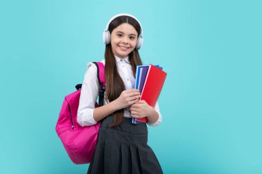 Okula dönelim. Okul çantalı kulaklıklı liseli kız öğrenci izole stüdyo geçmişi üzerine kitap tutuyor. Okul ve eğitim kavramı