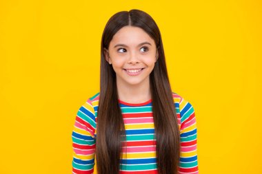 Mutlu yüz, pozitif ve gülümseyen genç kız duyguları. Sarı arka planda çocuk stüdyosu portresi. Çocukluk yaşam tarzı konsepti. Sevimli genç kız yüzü. Yakından.