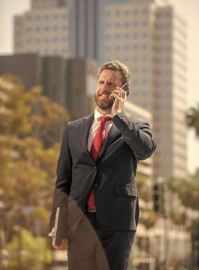 Telefon bağlantısı. Cep telefonundaki neşeli CEO konuşması. Telefon var. mobil teknoloji. İletişim. İş adamı akıllı telefonda konuşur. Patron adam konuşuyor. İş görüşmesi. ses bağlantısı.