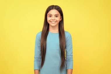 Sarı arka planda uzun saçlı mutlu çocuk, moda..