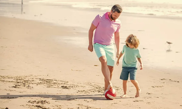 father and son play football on summer beach with ball, relationship.