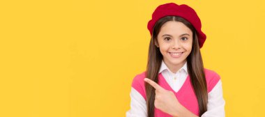 teenage beauty. tween and youth. casual fashion. happy french teen girl pointing finger. Child face, horizontal poster, teenager girl isolated portrait, banner with copy space