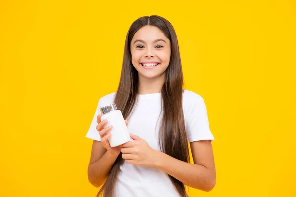 Teen girl with natural pill products. Presenting vitamin product, pharmacy. Happy teenager portrait. Smiling girl