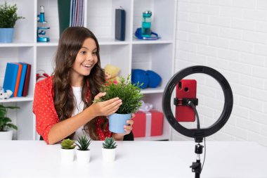 Video bloğu için kameranın önünde konuşan genç kız. Blogcu olarak çalışan bir genç, video blogu kaydediyor. Mutlu kız yüzü, pozitif ve gülümseyen duygular
