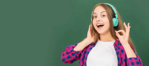 Cheerful Child Listen Music Headphones Blackboard Portrait Schoolgirl Student Studio — Zdjęcie stockowe
