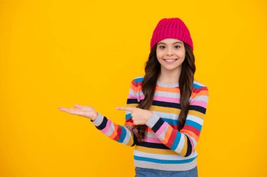 Winter hat. Cold season concept. Winter fashion accessory for children. Teen girl wearing warm knitted hat. Happy teenager, positive and smiling emotions of teen girl
