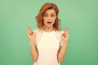 Duygularını ifade et. Kıvırcık saçlı, hayret verici bir kadın. Dilek tutuyorum. Kadın manken. Genç bir kızın güzel görünüşü. Mavi arka planda kızıl saçlı kadının portresi. Şaşkınlık.