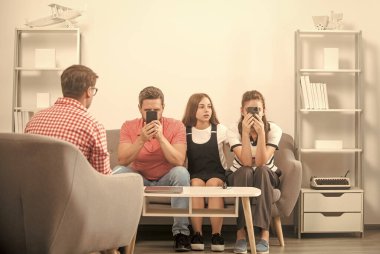 Veli toplantısı. Baba ve çocuk psikolog seansında. Aile terapisi. Çocuklu aileler sosyal hizmetlilerle konuşur. Telefon bağımlısı anne, baba ve kız. hayat sigortası ve evlat edinme.