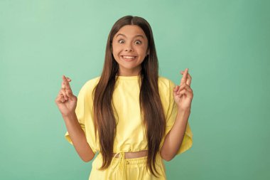 Şaşkın çocuk şans diledi. Güzellik ve moda. Kadın manken. Genç bir kızın güzel görünüşü. Mavi arka planda çocuk portresi. Olumlu duygularını ifade et. Şans diliyor..