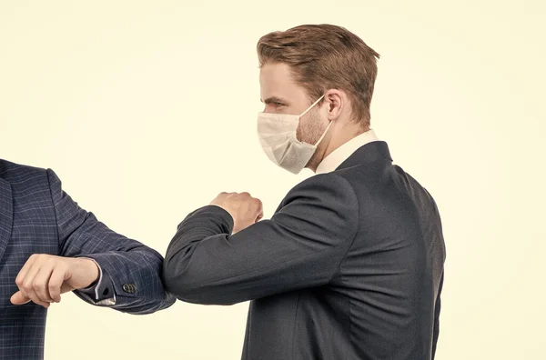 Elbow bump is the new handshake. Broker in face mask elbow bump with man. Elbow bumping. Coronavirus greeting. Covid-19 new reality.
