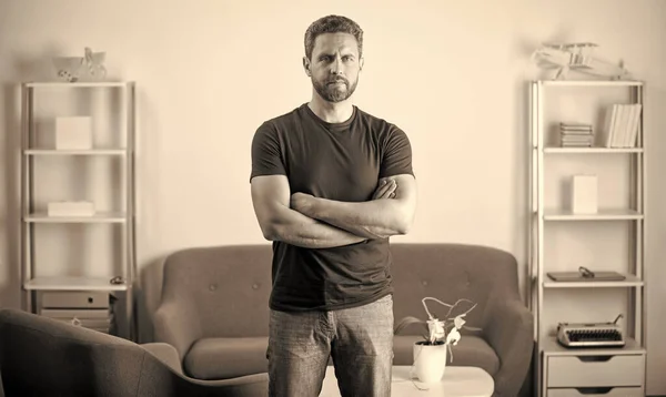 confident man crossed hands. male fashion model. handsome mature guy with beard. portrait of bearded man on office background. express emotions. serious face.