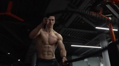 fitness gym. man practice fitness with battle ropes. muscular man training with battle ropes in fitness gym.