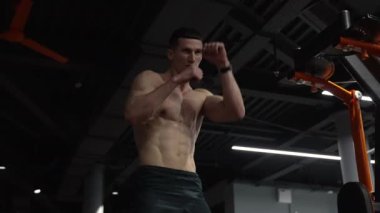 muscular sportsman boxing in fitness gym. strong sportsman punching and boxing. sportsman punching in sport gym.