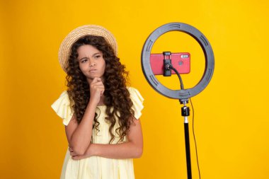 Teenager recording online media video. Teen girl streaming online and sharing social media content by mobile phone app network. Thinking teenage girl, thoughtful emotion