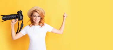 glad successful redhead woman photographer with camera in straw hat making photo, happiness. Woman isolated face portrait, banner with mock up copy space