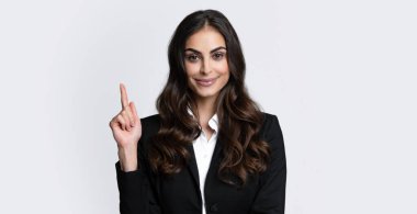 Portrait of young woman pointing her finger in eureka sign, having great innovative idea, solution just got. Female employee young secretary