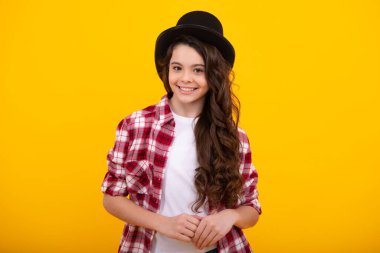 Child in magician hat, cylinder hat isolated on yellow background
