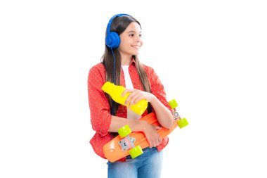 Gençlik gündelik kültürü. İzole edilmiş stüdyo geçmişi olan kaykaylı bir genç kız. Moda kıyafetleri içinde bir genç.