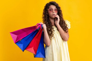 Sale and shopping concept. Teen girl holding shopping bags, isolated on studio background. Shocked amazed face, surprised emotions of young teenager girl. Summer shopping sale