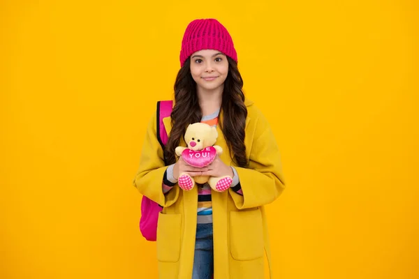 Autumn school. Funny school girl with toy isolated on yellow background. Happy childhood and kids education. Happy teenager, positive and smiling emotions of teen girl