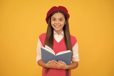 Çok heyecanlıyım. Bereliçocuk çalışmaya hazır. Gülümseyen çocuk kitabı okuyor. Genç bir öğrenci. Edebiyat. Eğitim. Mutlu Fransız genç kız defterini tutuyor. çocukluk mutluluğu. Okula geri dön..