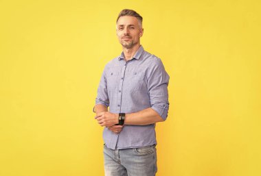 Gülümseyen yetişkin adam sarı arka planda gri saçlı, moda.