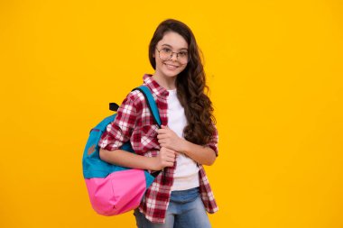 Back to school. Teenage school girl ready to learn. School children on yellow isolated background. Happy teenager, positive and smiling emotions of teen girl