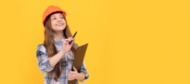 childhood development. happy labour day. future career. teen girl in helmet making notes. Child in hard hat horizontal poster design. Banner header, copy space