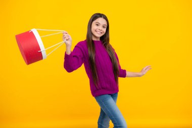 Shopping bags in the kids hands. Teen girl after shopping. Purchases, black friday, discounts and sale concept
