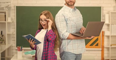 Şok olmuş öğrenci ve bilgisayar öğretmeni. Baba ve genç kız ders çalışıyor. Özel öğretmen ve çocuk defterini tutuyor. Aile yardımı. Baba ve kızı defter kullanıyor. Okula dönüyorum. çocukluk eğitimi.