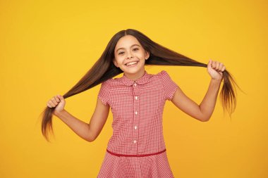Sarı arka planda çocuk stüdyosu portresi. Çocukluk yaşam tarzı konsepti. Sevimli genç kız yüzü. Yakından.