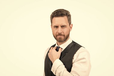 Beyaz arka planda izole edilmiş, resmi giyinmiş, gülümseyen, tıraşsız, olgun bir adamın portresi..