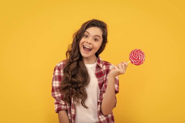 Lolipop çocuk. Uzun kıvırcık saçlı hippi çocuk lolipopu tutuyor. Çubukta şeker. Karamelli şeker dükkanı. Tatlı çocukluk hayatı. Genç diş bakımı. Tatlı düşkünü. Lezzetli. Komik kız lolipopu tut.