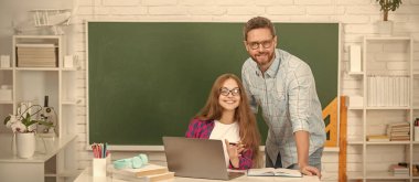 Bilgisayarda özel öğretmen ve çocuk. Aile yardımı. Baba ve kızı Clackboard 'un yanında. Okula dönüyorum. Çocukluk eğitimi. Mutlu öğrenci ve dizüstü bilgisayarı olan özel öğretmen. baba ve genç kız çalışıyor..