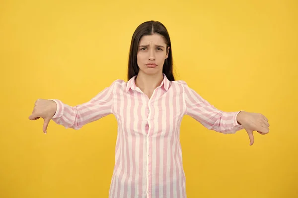 Negative woman show no decline forbidden rule isolated over yellow background. Woman point down at copy space, showing copyspace pointing down. Displeased angry woman, negative