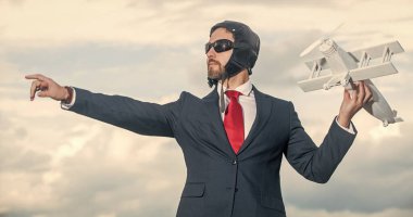 Takım elbiseli iş adamı ve pilot şapkalı uçak oyuncağı..