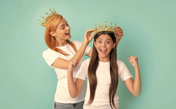 Beauty pageant winner. Beauty queen and happy winner. Woman crown girl child. Mother and daughter making winning gesture. Euphoria of victory.