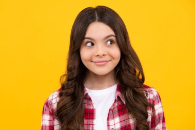 Happy teenager, positive and smiling emotions of teen girl. Portrait of cute positive little girl isolated on yellow background. Attractive caucasian child smiling and looking at camera