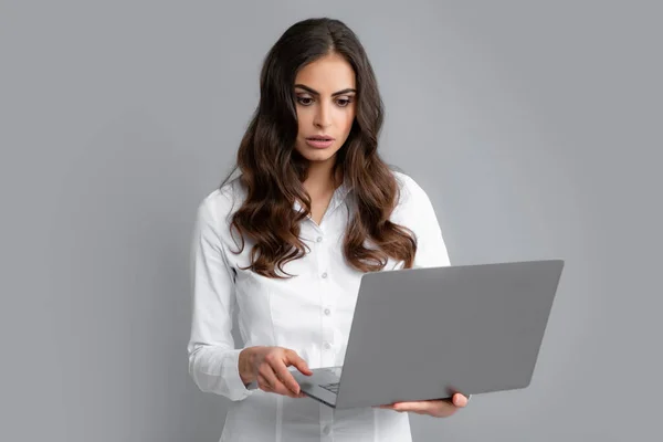 Pretty assistant holding notebook search information internet. Young business woman with laptop computer isolated studio portrait on gray background. Freelancer at work