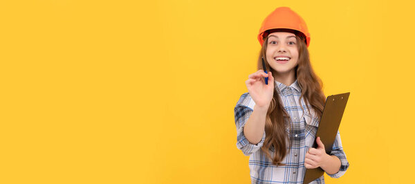 happy teen girl in helmet and checkered shirt making notes on clipboard, childhood. Child in hard hat horizontal poster design. Banner header, copy space
