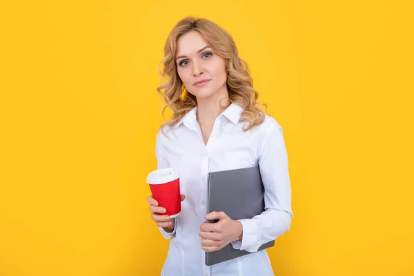 blonde woman with coffee cup and computer on yellow background.