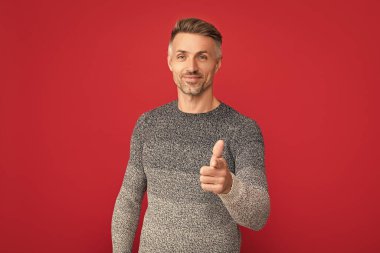 Kırmızı arka planda süveter giyen gülümseyen adam, yaşam tarzı.