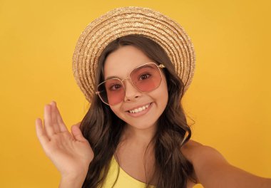 çocukluk mutluluğu. Yaz partisi görünüşü. Gözlüklü ve hasır şapkalı mutlu çocuk. Havalı genç kız eğleniyor. Gözlüklü neşeli çocuk selfie çekiyor. Moda aksesuarı. pozitifliği ifade et.