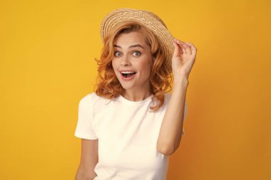 Şaşırmış yüzlü, etkileyici bir kız. Sarı arka planda zarif hasır şapkalı güzel bir kadın.