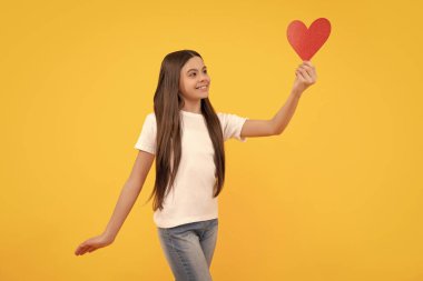 Neşeli çocuk, aşk kalbini sarı arka planda tut, tatlım..