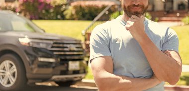 Mahallede araba ve evin yanında duran kırpılmış bir adam. Boşluğu kopyala.