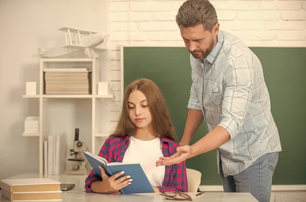 father and teen girl study. private teacher and child hold copybook. family help. dad and daughter use notebook. friendship. back to school. childhood education. busy pupil and tutor.